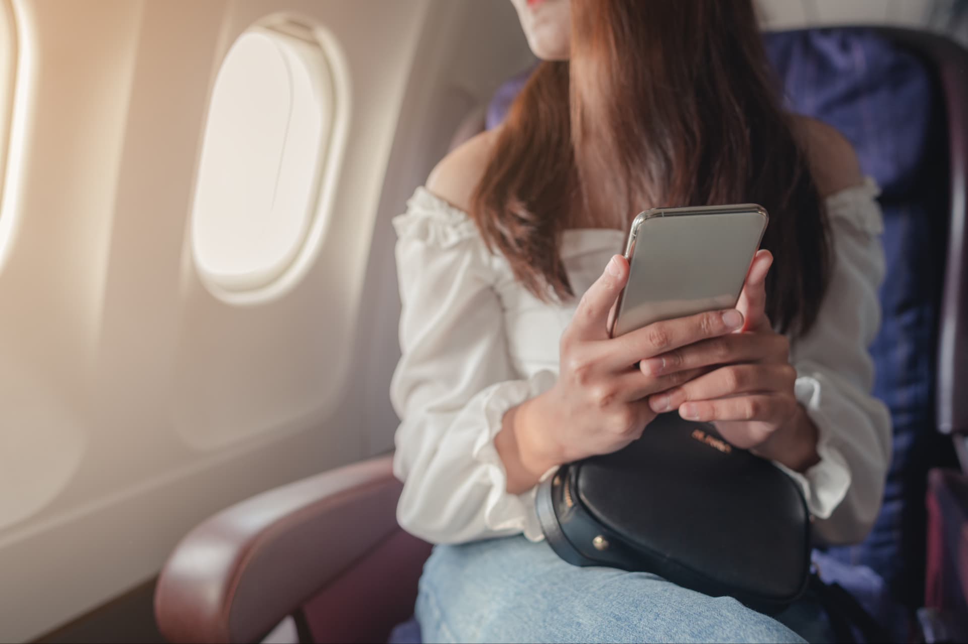 https://s3.merlines.ru:443/dev-cms/young_woman_sitting_near_airplane_window_sunset_using_mobile_phone_flight_airplane_1_b6249d6801.avif